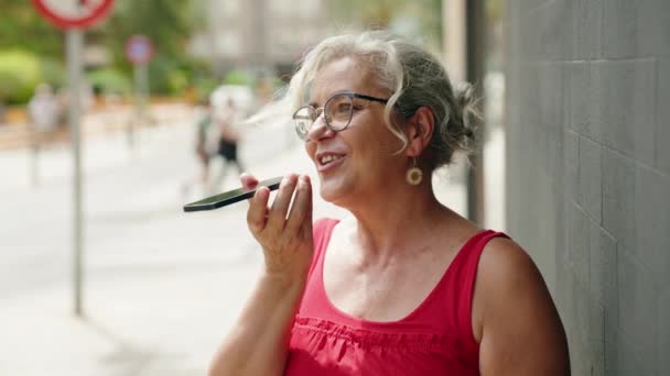 Medelålders Gråhårig Kvinna Ler Tryggt Talar Smartphone Gatan — Stockvideo