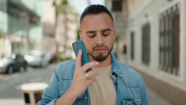 Young Hispanic Man Worried Talking Smartphone Street — Stockvideo