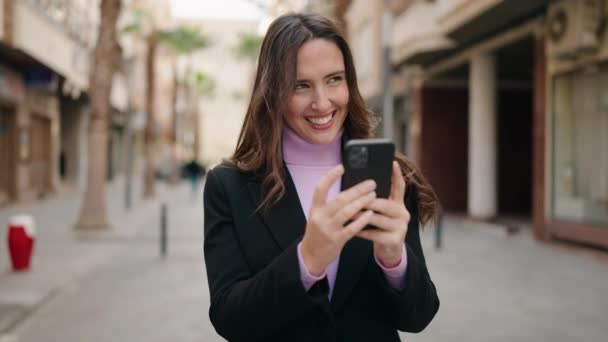 年轻的惊慌失措的女人在街上用智能手机充满自信地微笑 — 图库视频影像