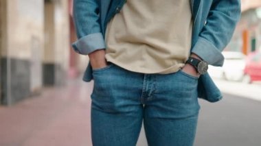 Young hispanic man showing empty pockets at street