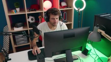 Genç İspanyol asıllı adam müzik stüdyosunda video oyunu oynuyor.