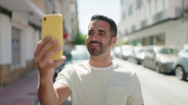 Latin asıllı genç adam gülümsüyor.