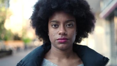 Sokakta ciddi bir ifadeyle yürüyen Afrikalı Amerikalı kadın.