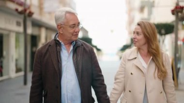 Middle age couple couple walking with hands together at street