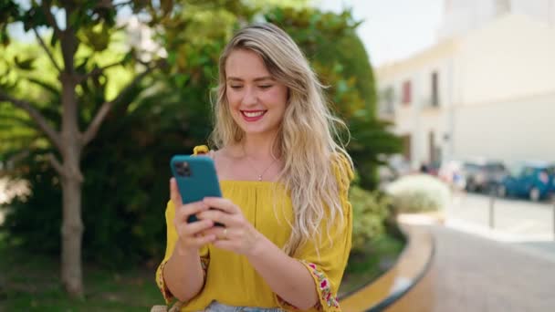 Νεαρή Γυναίκα Χαμογελά Αυτοπεποίθηση Χρησιμοποιώντας Smartphone Στο Πάρκο — Αρχείο Βίντεο