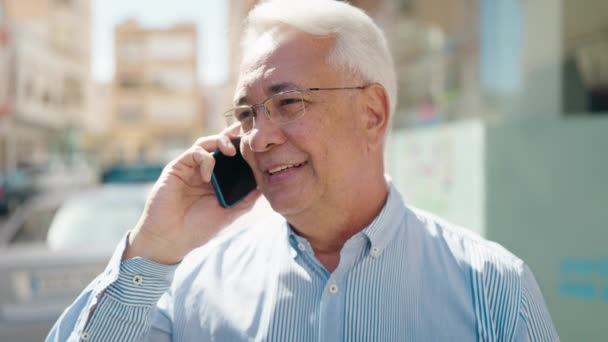 Hombre Mayor Sonriendo Confiado Hablando Teléfono Inteligente Calle — Vídeos de Stock