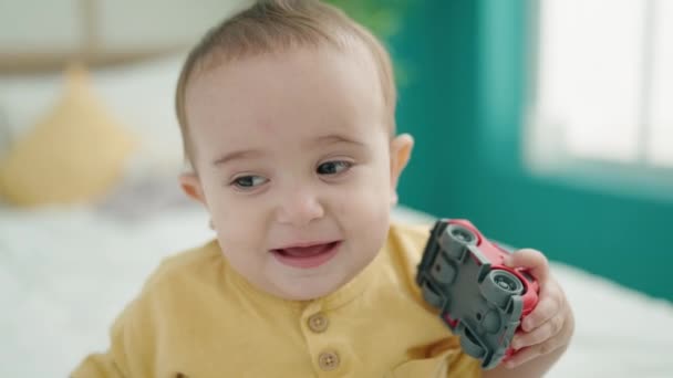 Bedårande Latinamerikansk Bebis Som Leker Med Bilen Sittandes Sängen Sovrummet — Stockvideo