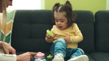 Evdeki koltukta oturan sevimli İspanyol kız oyuncağını emiyor.