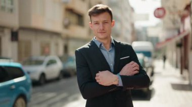 Young caucasian man smiling confident standing with arms crossed gesture at street