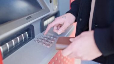 Caddedeki banka makinesinde şifreye basan genç bir Arap.