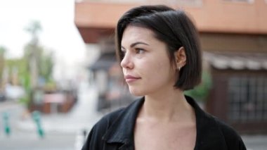 Young caucasian woman standing with serious expression at street