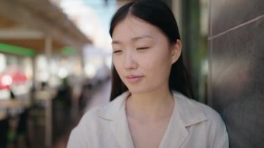 Sokakta kendinden emin gülümseyen Çinli kadın.