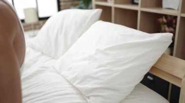 Genç İspanyol adam yatakta uzanıp yatak odasında uyuyor.