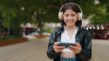 Parkta kendine güvenen genç İspanyol kadın gülümsüyor.