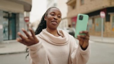 African american woman smiling confident having video call at street