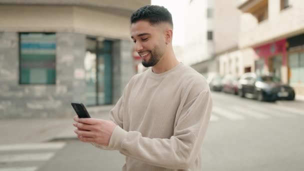 Jonge Arabier Man Glimlacht Vol Vertrouwen Met Behulp Van Smartphone — Stockvideo