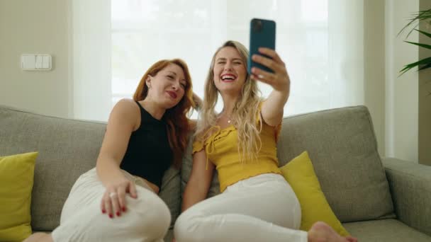 Dos Mujeres Que Tienen Videollamada Sentadas Sofá Casa — Vídeos de Stock