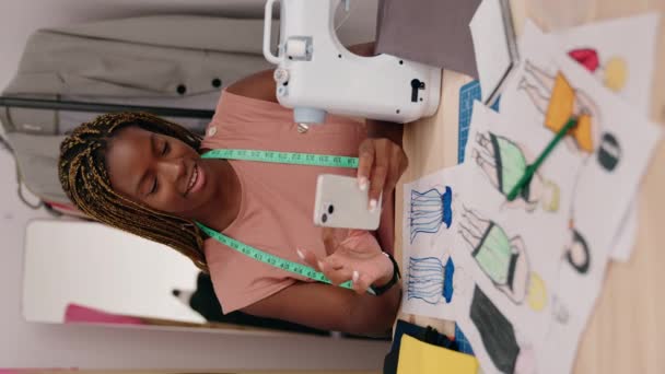 非洲裔美国女性裁缝在裁缝店使用智能手机垂直视频 — 图库视频影像
