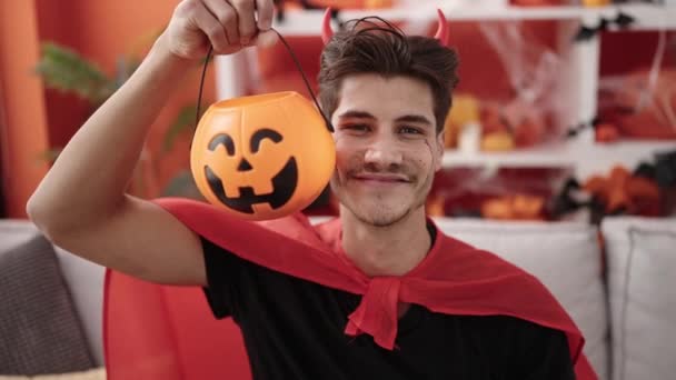 Young Hispanic Man Wearing Devil Costume Holding Halloween Pumpkin Basket — ストック動画