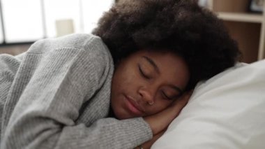 Afro-Amerikalı kadın yatakta uzanıyor. Yatak odasında uyuyor.