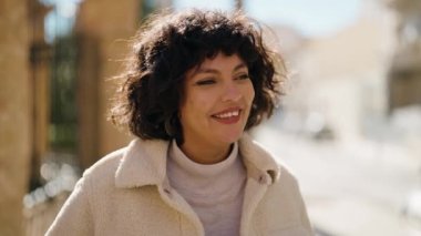 Sokakta kendine gülen genç İspanyol kadın.