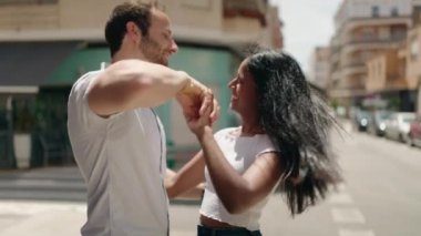 Man and woman interracial couple dancing at street