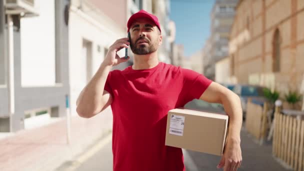 Genç Spanyol Teslimatçı Elinde Paketle Caddedeki Akıllı Telefondan Konuşuyor — Stok video