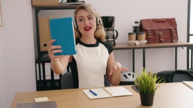 Young beautiful hispanic woman call center agent having video call at office