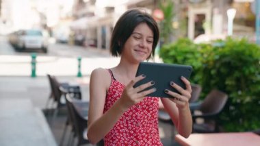 Adorable hispanic girl smiling confident watching video on touchpad at street