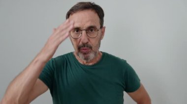 İzole edilmiş beyaz arka planda sürpriz bir ifadeyle duran orta yaşlı bir adam.