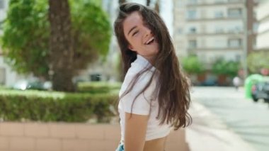 Parkta kendinden emin gülümseyen genç İspanyol kadın.