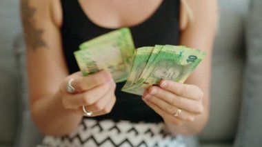 Güney Afrika 'da 10 rand banknot sayan genç bir kadın.
