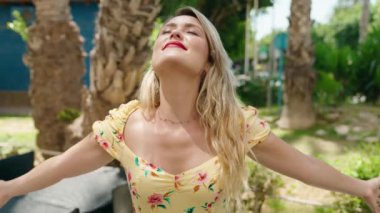 Genç, güzel İspanyol kadın gülümsüyor. Parkta nefes alıyor.