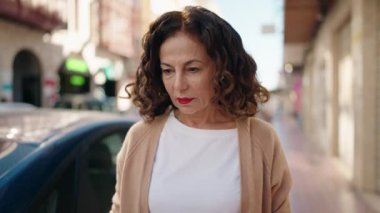 Sokakta duran orta yaşlı bir kadın.