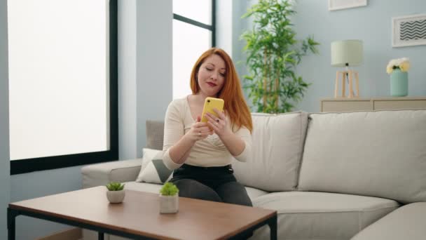 Jovem Ruiva Mulher Fazer Selfie Pelo Smartphone Sentado Sofá Casa — Vídeo de Stock