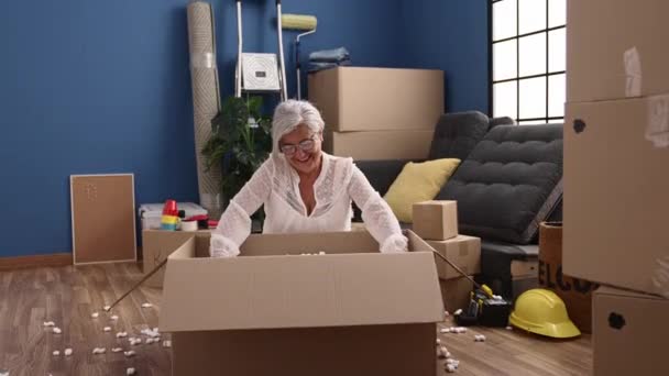 Middle Age Grey Haired Woman Smiling Confident Unboxing Package Playing — Vídeos de Stock