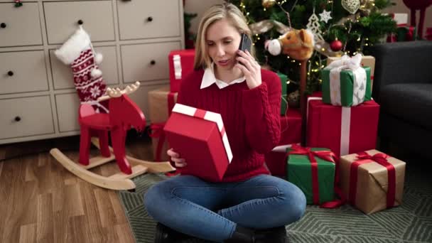 Jong Blond Vrouw Praten Smartphone Holding Christmas Gift Thuis — Stockvideo