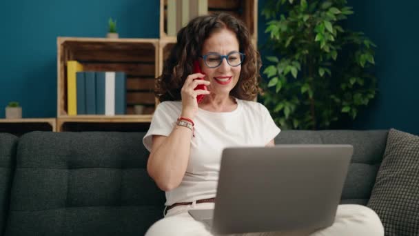 Kobieta Średnim Wieku Rozmawia Przez Smartfona Pomocą Laptopa Domu — Wideo stockowe