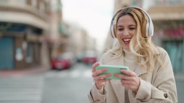 Joven Mujer Rubia Sonriendo Confiado Jugando Videojuego Calle — Vídeo de stock