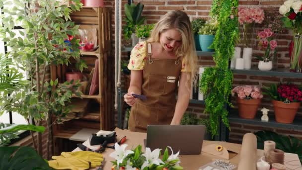 年轻美丽的惊慌失措的女花匠在花店用笔记本电脑和信用卡 — 图库视频影像