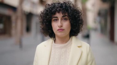 Sokakta ciddi bir ifadeyle duran genç bir kadın.