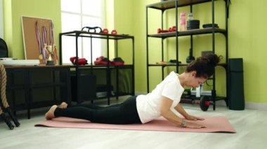 Orta yaşlı İspanyol kadın spor merkezinde yoga eğitimi alıyor.