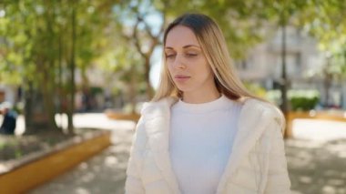 Young woman with relaxed expression standing at park