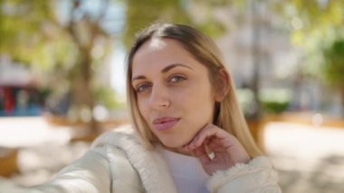 Young woman smiling confident making selfie by the camera at park