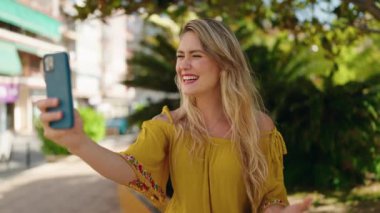 Young woman smiling confident having video call at park