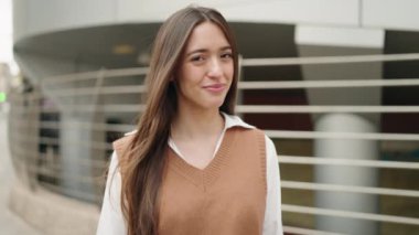 Sokakta kendine gülen genç İspanyol kadın.