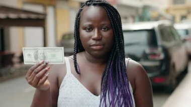 Afrikalı Amerikalı kadın sokakta 100 dolar bozuyor.