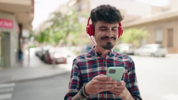 Νεαρός Ισπανός Χαμογελάει Αυτοπεποίθηση Ακούγοντας Μουσική Και Χορεύοντας Στο Δρόμο — Αρχείο Βίντεο