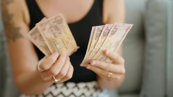 年轻女子在家里数着5枚迪拉姆钞票 — 图库视频影像