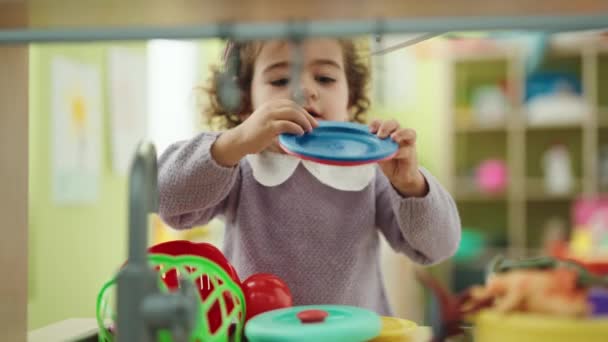 可爱的惊恐女孩站在幼儿园里玩着游戏厨房 — 图库视频影像
